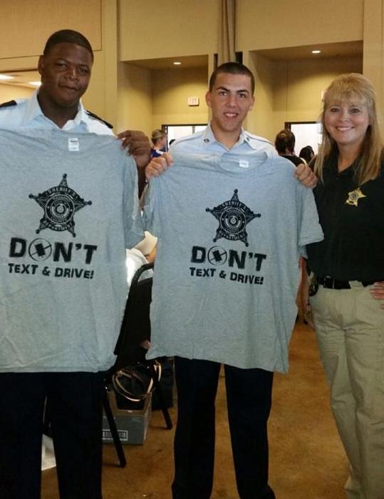 Officers holding don't text and drive shirt