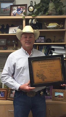 Sheriff Tanner holding a plaque of appreciation  