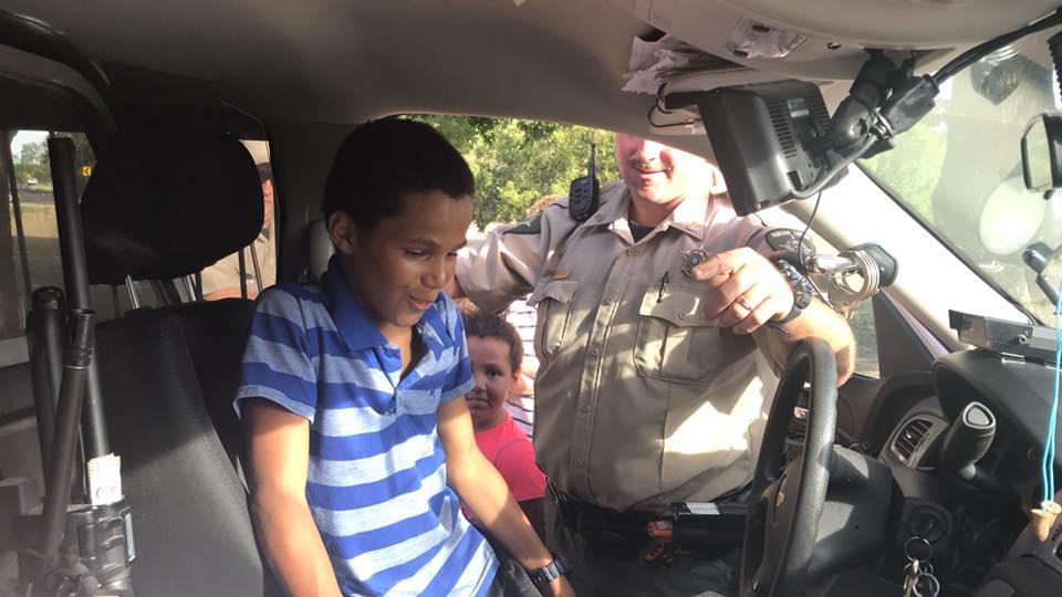 Josh Erwin smiles as he gets to sit in the front see of a NCSO Police Vehicle