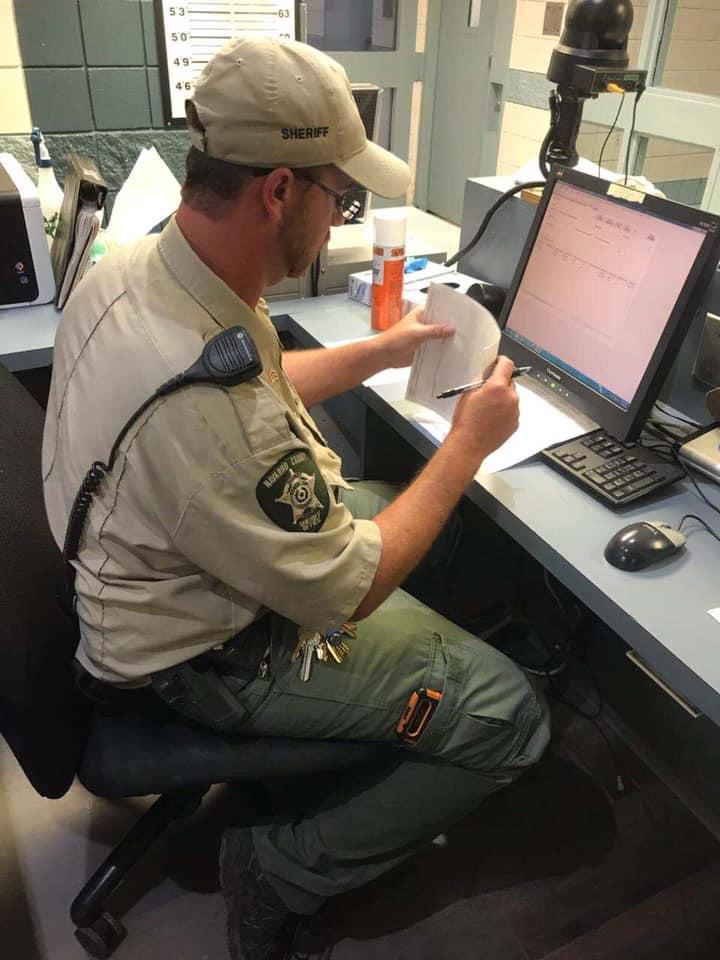 Male correctional officer checking information