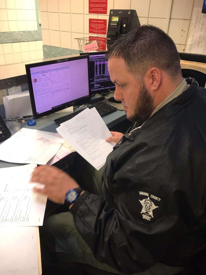 Male correctional officer looking over paperwork