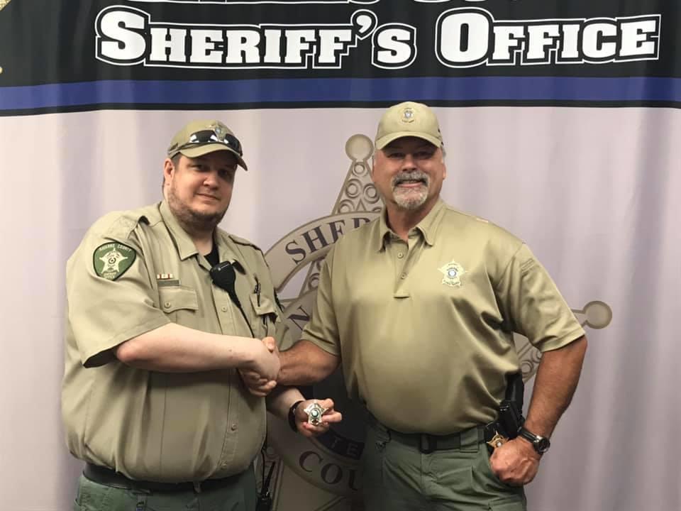 Corporal Andrew Adams shaking hands with Sheriff