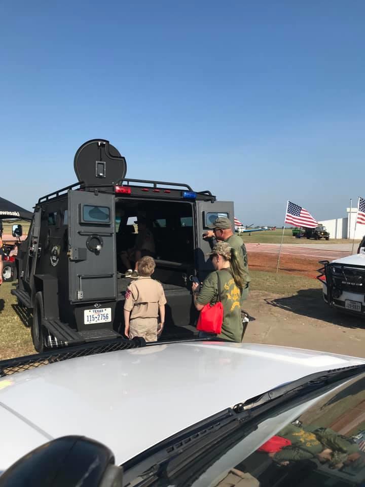 People looking inside the armored vehicle from the back