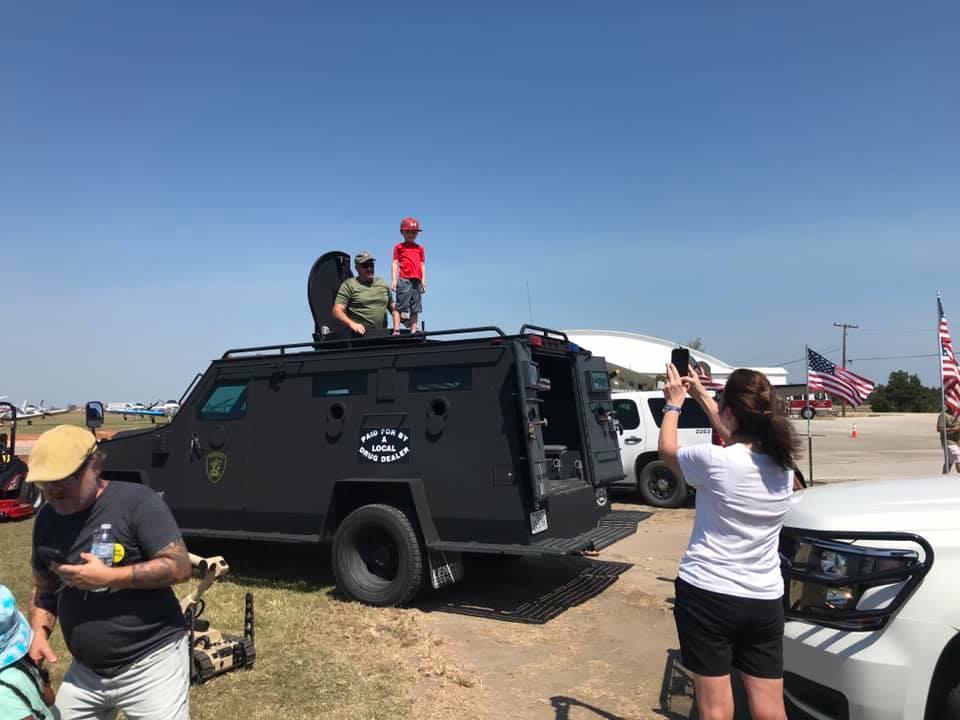 young boy on roof of armored vehicle