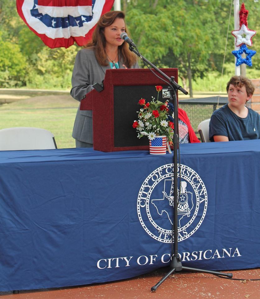 A lady giving a speech behind the podium