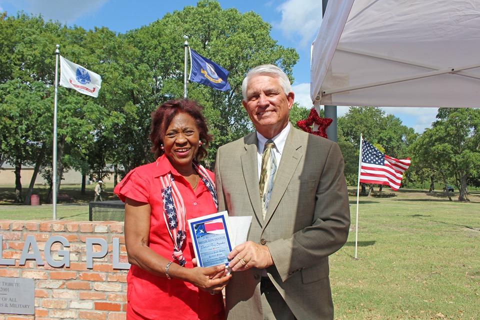 A man congratulating a woman who is holding a flyer