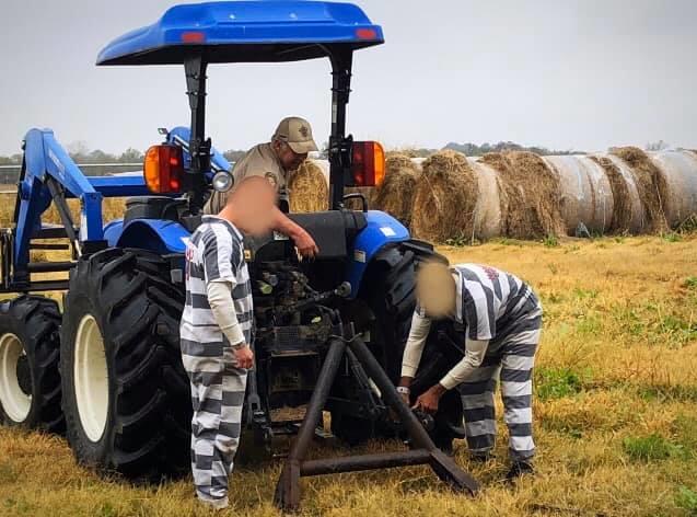 Inmates working on a tractor