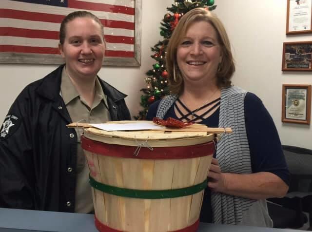 deputy with citizen posing with holiday basket