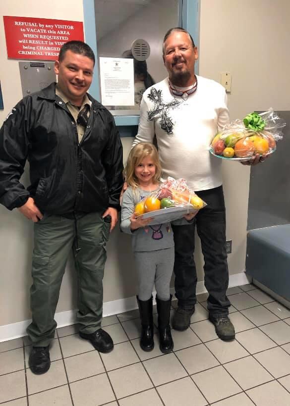deputy and citizens pose with donated holiday treats