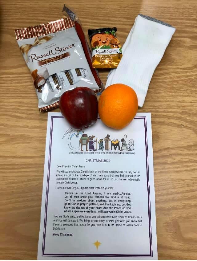 a holiday care package with snacks and fruit and a letter