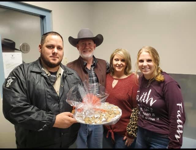 office staff and citizens posing with a plate of Christmas cookies