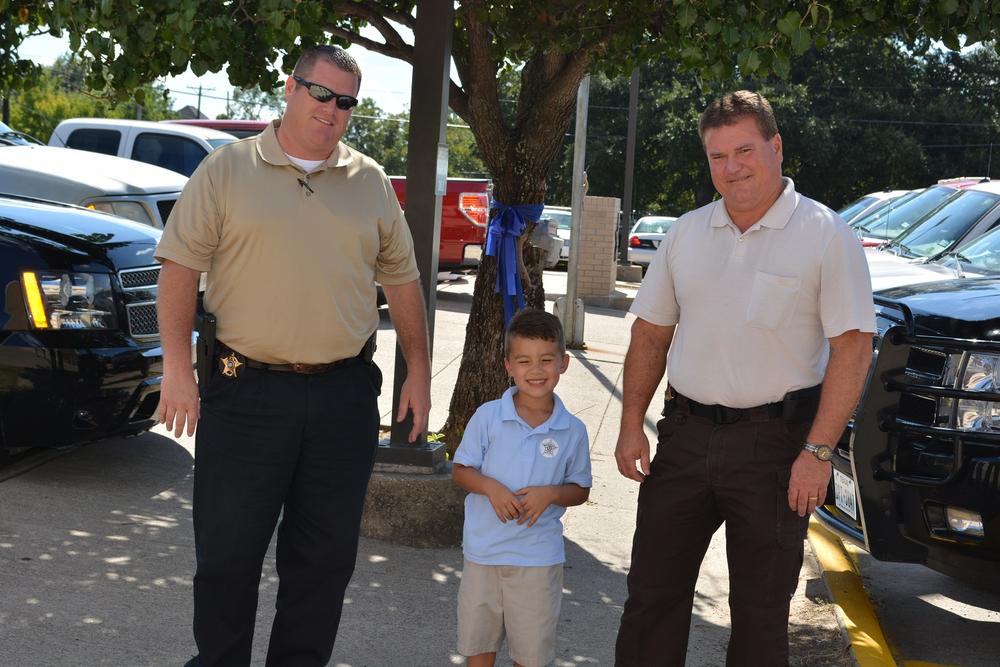 Eli Clagett standing between 2 officers