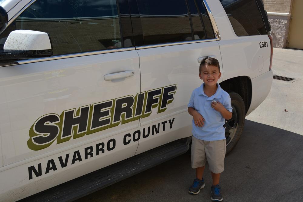 Eli Clagett standing next to a Sheriff's vehicle