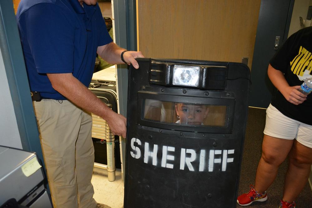 Eli Clagett standing behind a swat shield