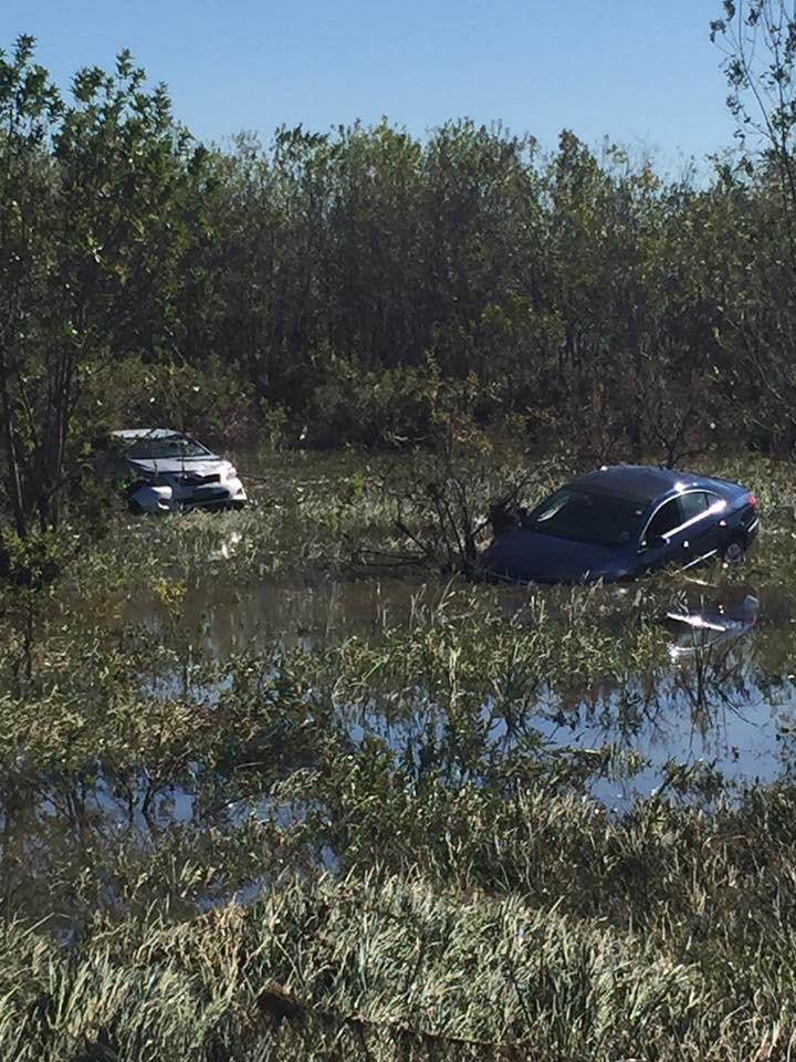 Two cars submerged in water from flood damage
