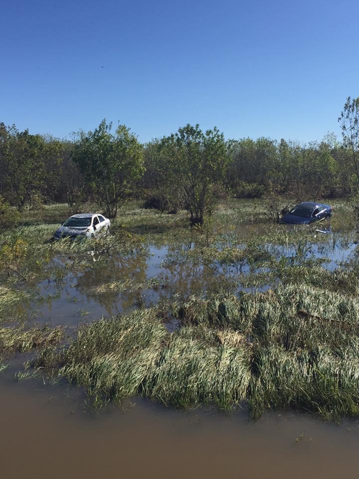 Two cars submerged in water from flood damage