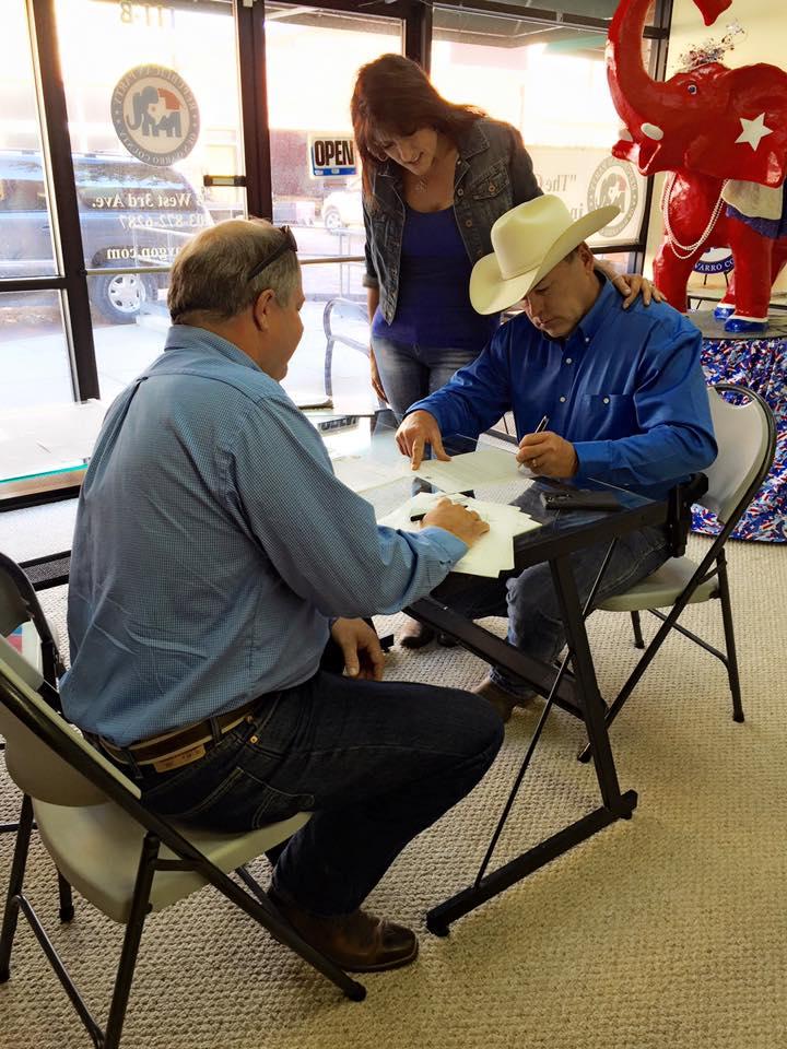 Sheriff Tanner sitting at a table with others at a polling place 