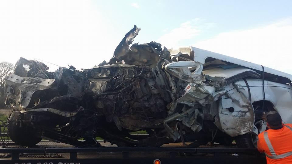 Damage done to a small pickup truck after a head-on collision with a semi-truck