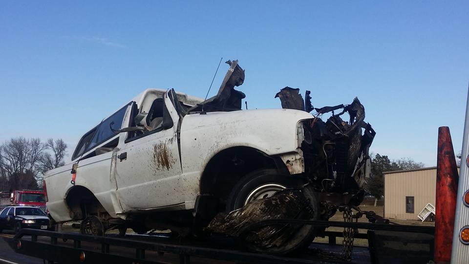 Damage done to a small pickup truck after a head-on collision with a semi-truck