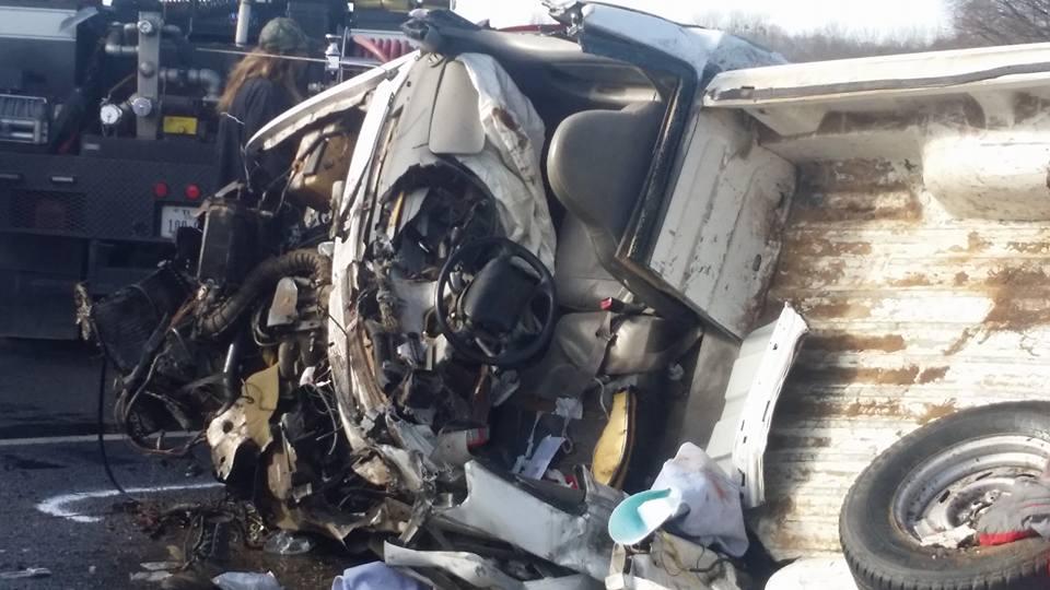 Damage done to a small pickup truck after a head-on collision with a semi-truck