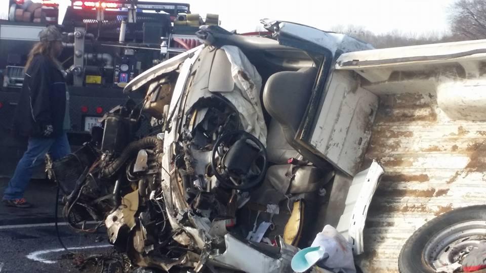 Damage done to a small pickup truck after a head-on collision with a semi-truck