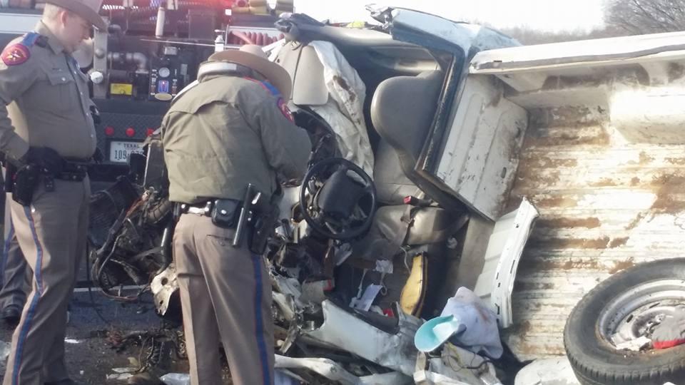 Damage done to a small pickup truck after a head-on collision with a semi-truck