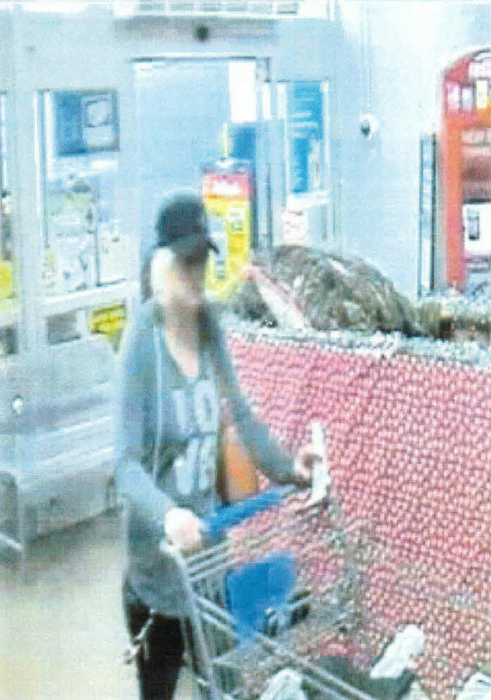 Person in long sleeve shirt and ball cap, pushing a shopping cart