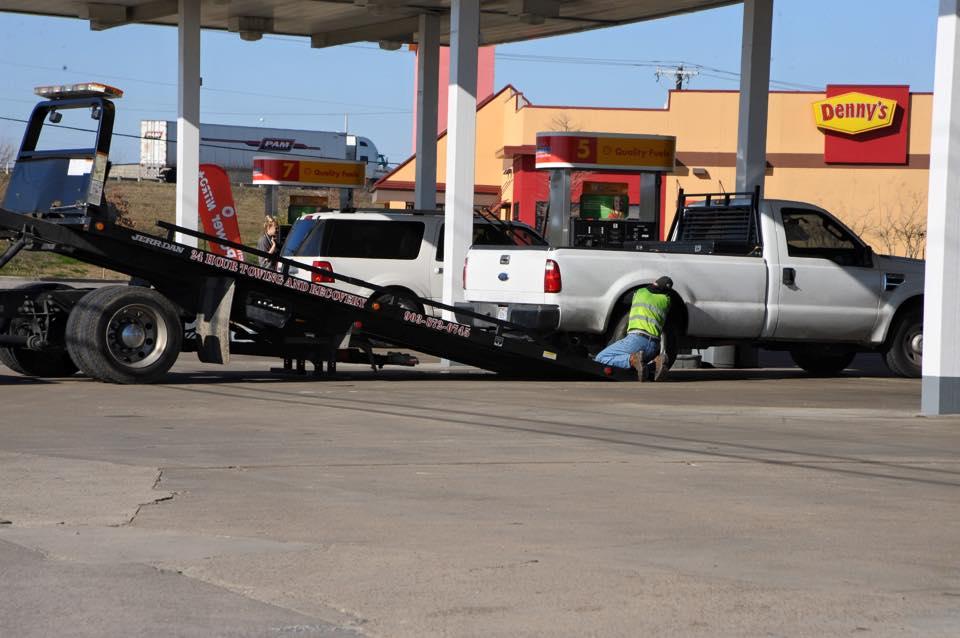 Pick-up truck being loaded onto to a tow truck 