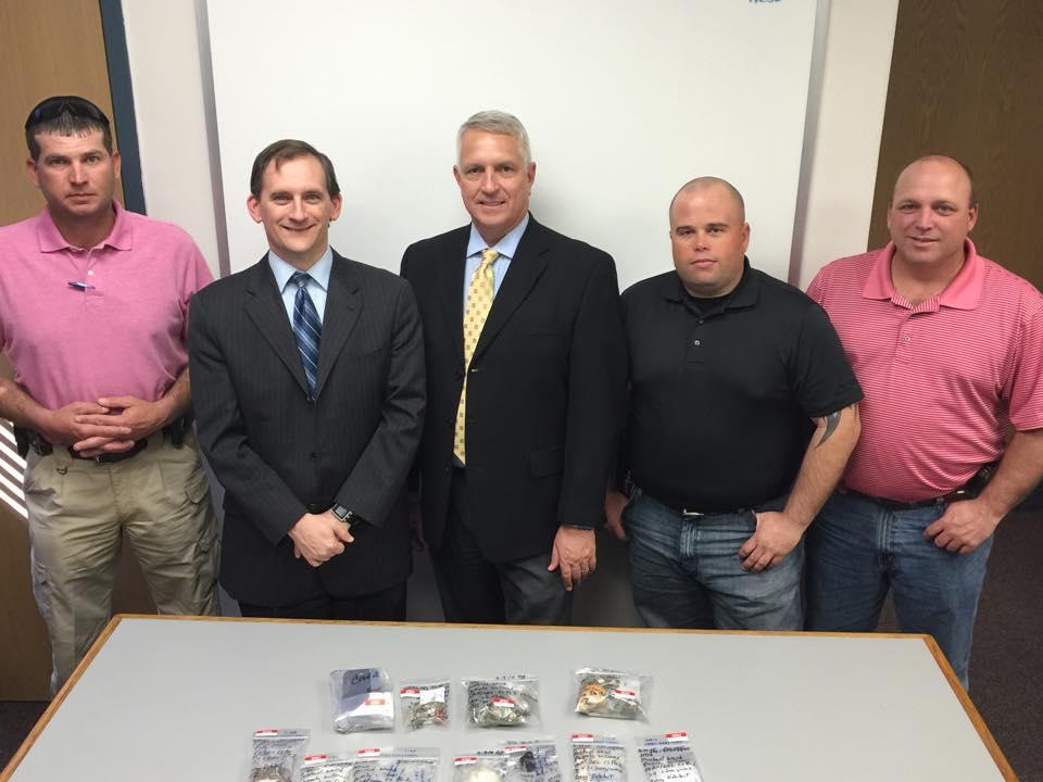 Officer stand together after a drug bust 