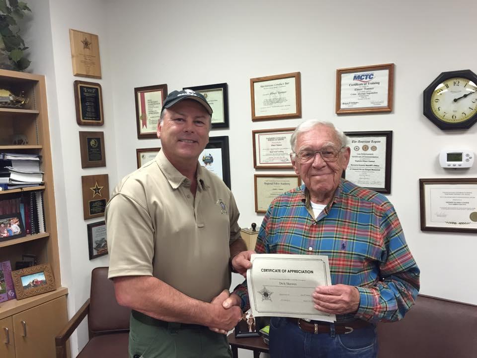 Sheriff Tanner presents Mr. Dick Skewes with a certificate of appreciation