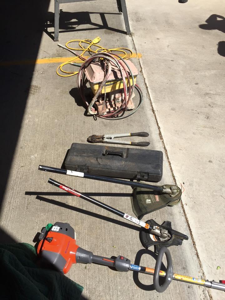 Weed eater and other tools on the ground 