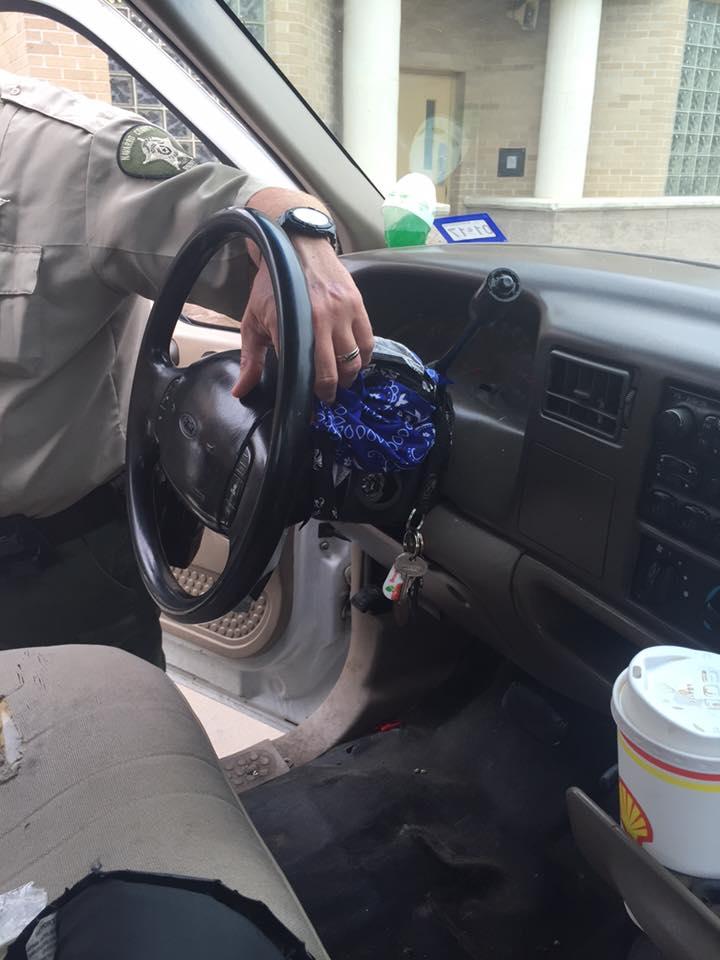 An officer showing the damage to the stolen vehicles ignition