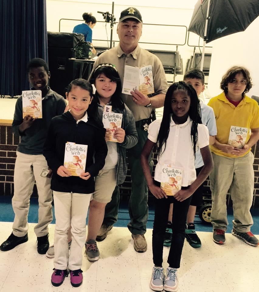 Sheriff Tanner poses with a group of 4th graders after reading to them