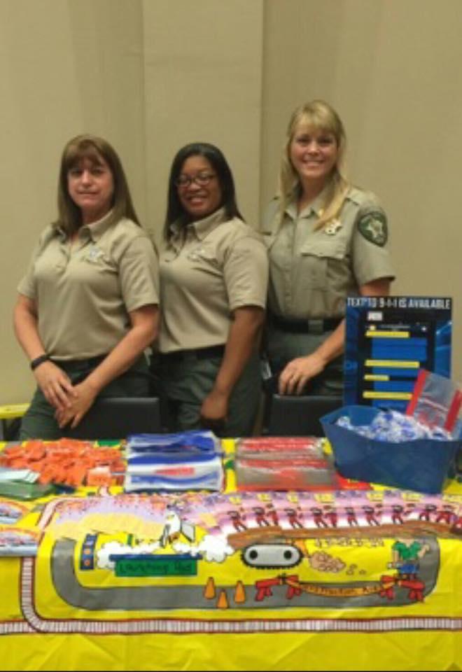 Sergeant Melanie Cagle, Pshaun Martin and Tammy Sloan pose for group photo at the back to schoolo rally 