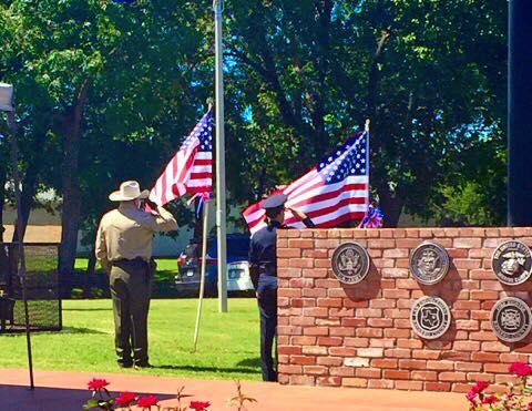 Officers standing at attention as the flag is raised