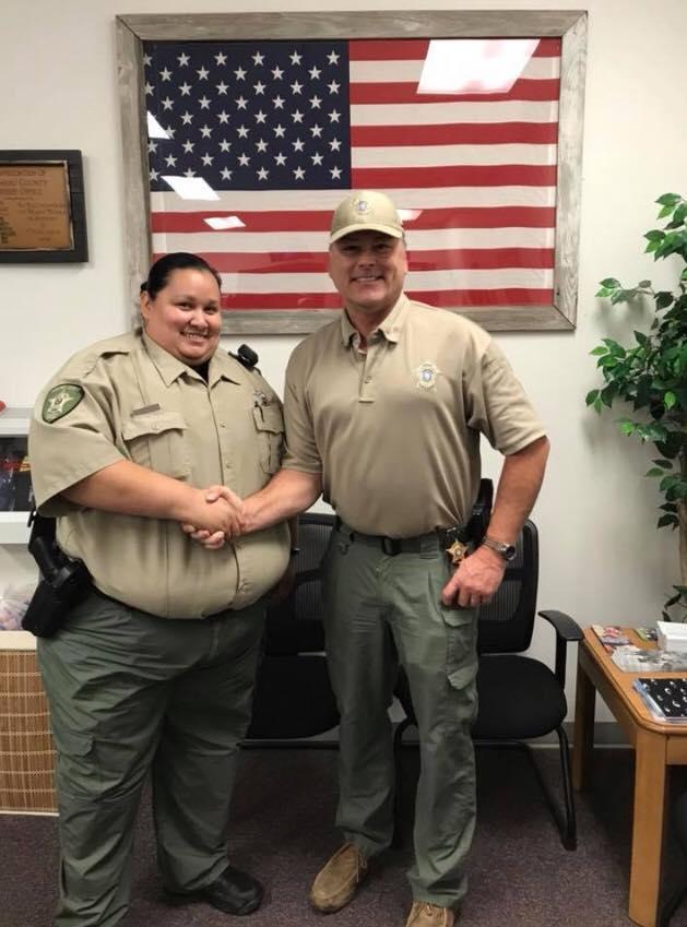 Deputy Kathy Basnett shakes Sheriff Tanner's hand